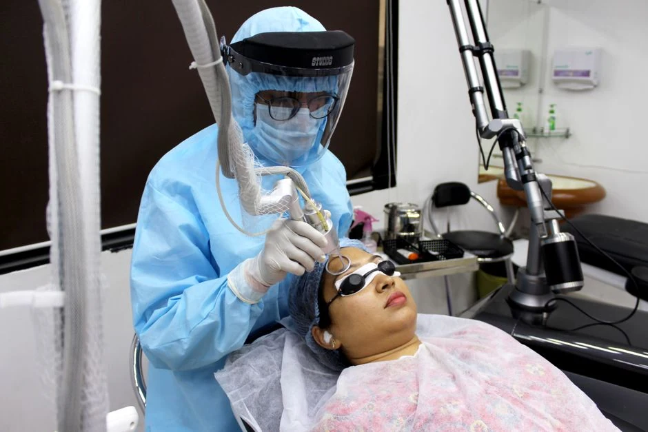 Medical practitioner performing a fractional facial laser treatment in a clinical setting