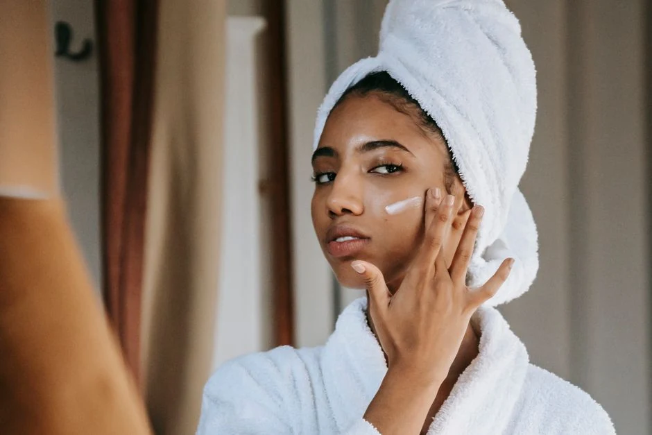 Woman gently applying facial moisturizer while following a skin-care routine