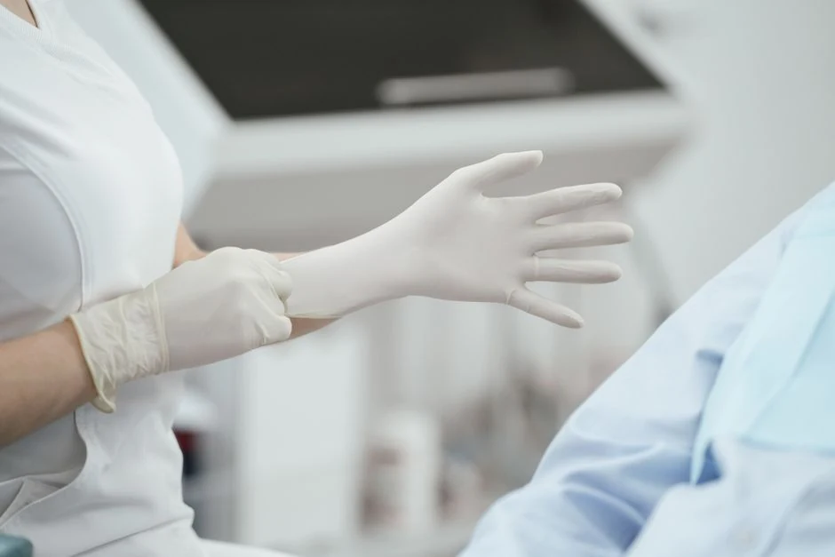 Medical practitioner putting on examination gloves before an in-office procedure